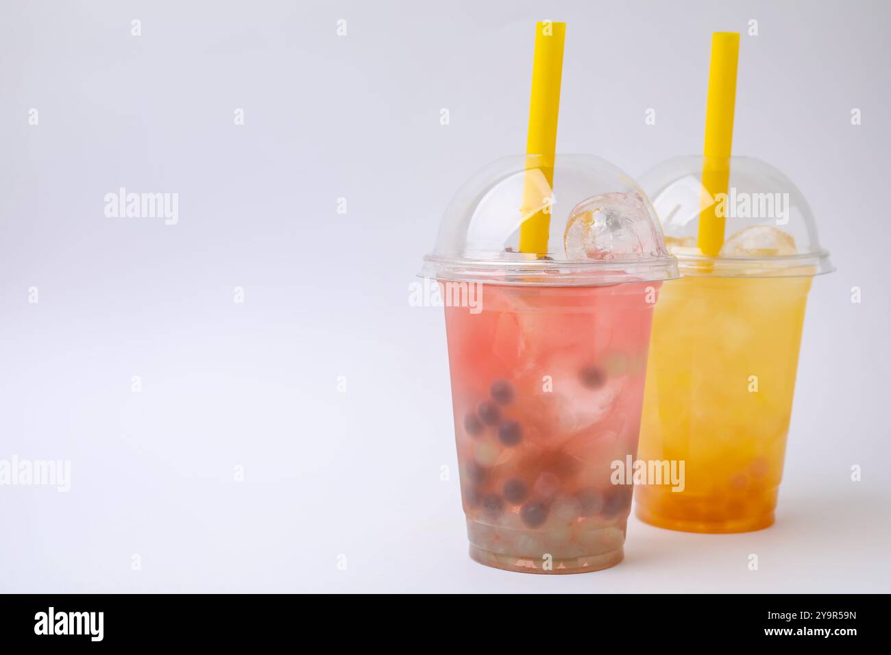 Leckerer Bubble Tee in Plastikbechern auf weißem Hintergrund Stockfoto