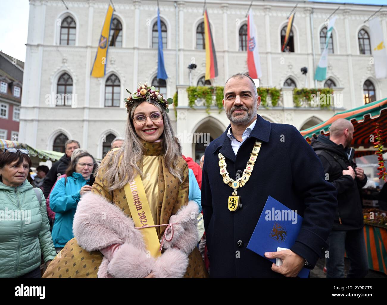 Weimar, Deutschland. Oktober 2024. Sarah Antonia Gallegos García als Sarah II. Zwiebelmarkt Königin 2024 und Peter kleine (nicht-Party), Oberbürgermeister von Weimar, stehen vor dem geschmückten Rathaus bei der Eröffnung des 371. Weimarer Zwiebelmarktes. Rund 400 Händler und Aussteller errichteten nach Angaben der Stadtverwaltung ihre Stände im Stadtzentrum für das älteste Volksfest Thüringens. Darüber hinaus zogen ein halbes Dutzend Kulturbühnen und spezielle Angebote für Kinder und Jugendliche Besucher auf den Zwiebelmarkt. Quelle: Martin Schutt/dpa/Alamy Live News Stockfoto