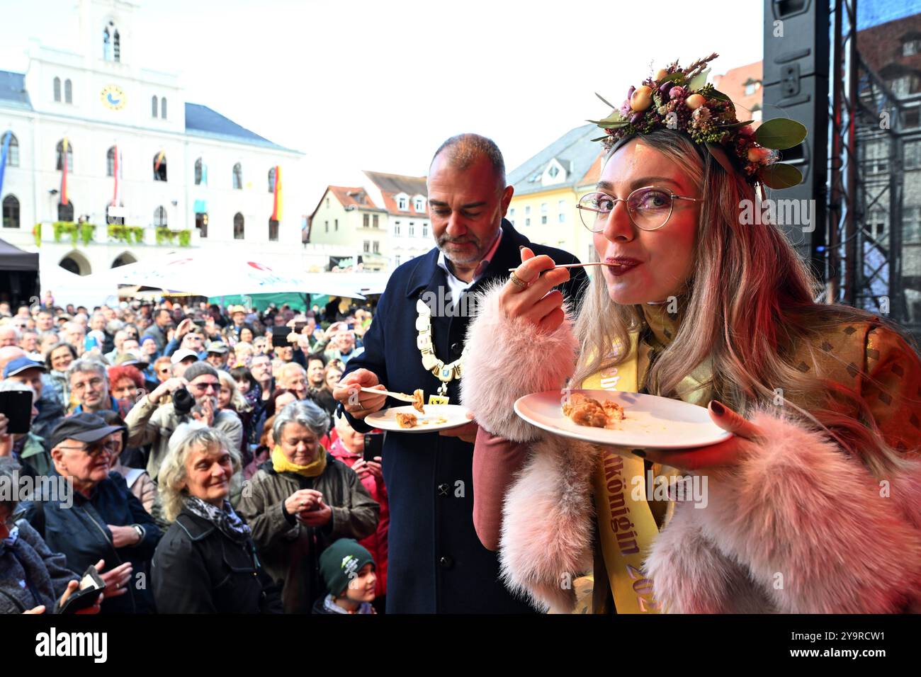 Weimar, Deutschland. Oktober 2024. Sarah Antonia Gallegos García als Sarah II Zwiebelmarkt Königin 2024 und Peter kleine (nicht-Party), Oberbürgermeister von Weimar, probieren die Zwiebeltorte bei der Eröffnung des 371. Weimarer Zwiebelmarktes. Rund 400 Händler und Aussteller richteten nach Angaben der Stadtverwaltung ihre Stände in der Innenstadt für das älteste Volksfest Thüringens ein. Darüber hinaus lockten ein halbes Dutzend Kulturbühnen und spezielle Angebote für Kinder und Jugendliche die Besucher zur 371. Ausgabe des Zwiebelmarktes an. Quelle: Martin Schutt/dpa/Alamy Live News Stockfoto