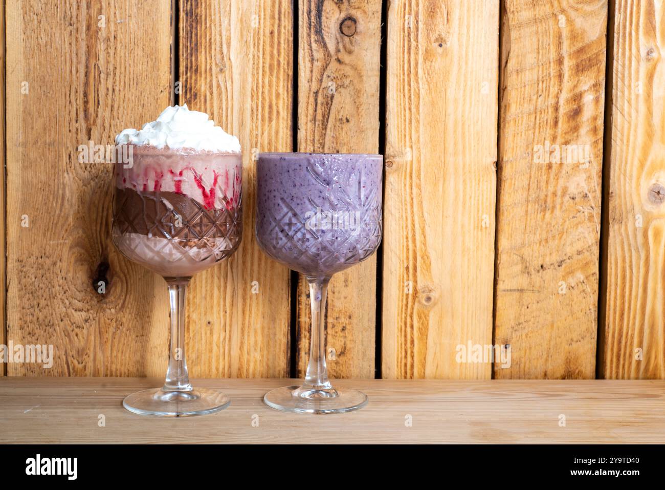 Erdbeeren- und Schokoladenmilchshake mit Sahne und Heidelbeer-Smoothie Stockfoto