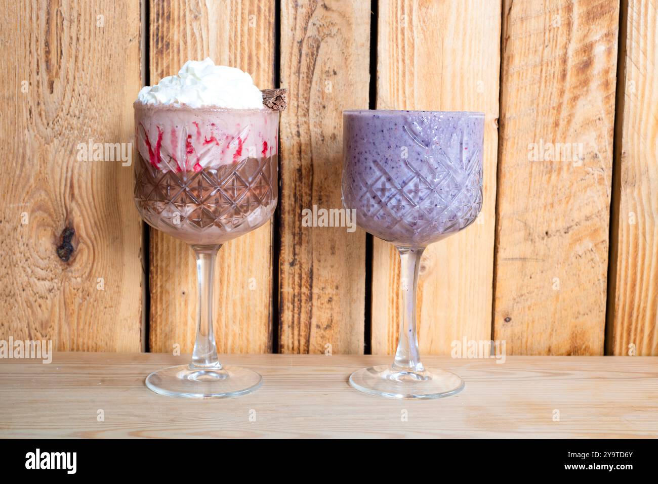 Erdbeeren- und Schokoladenmilchshake mit Sahne und Heidelbeer-Smoothie Stockfoto