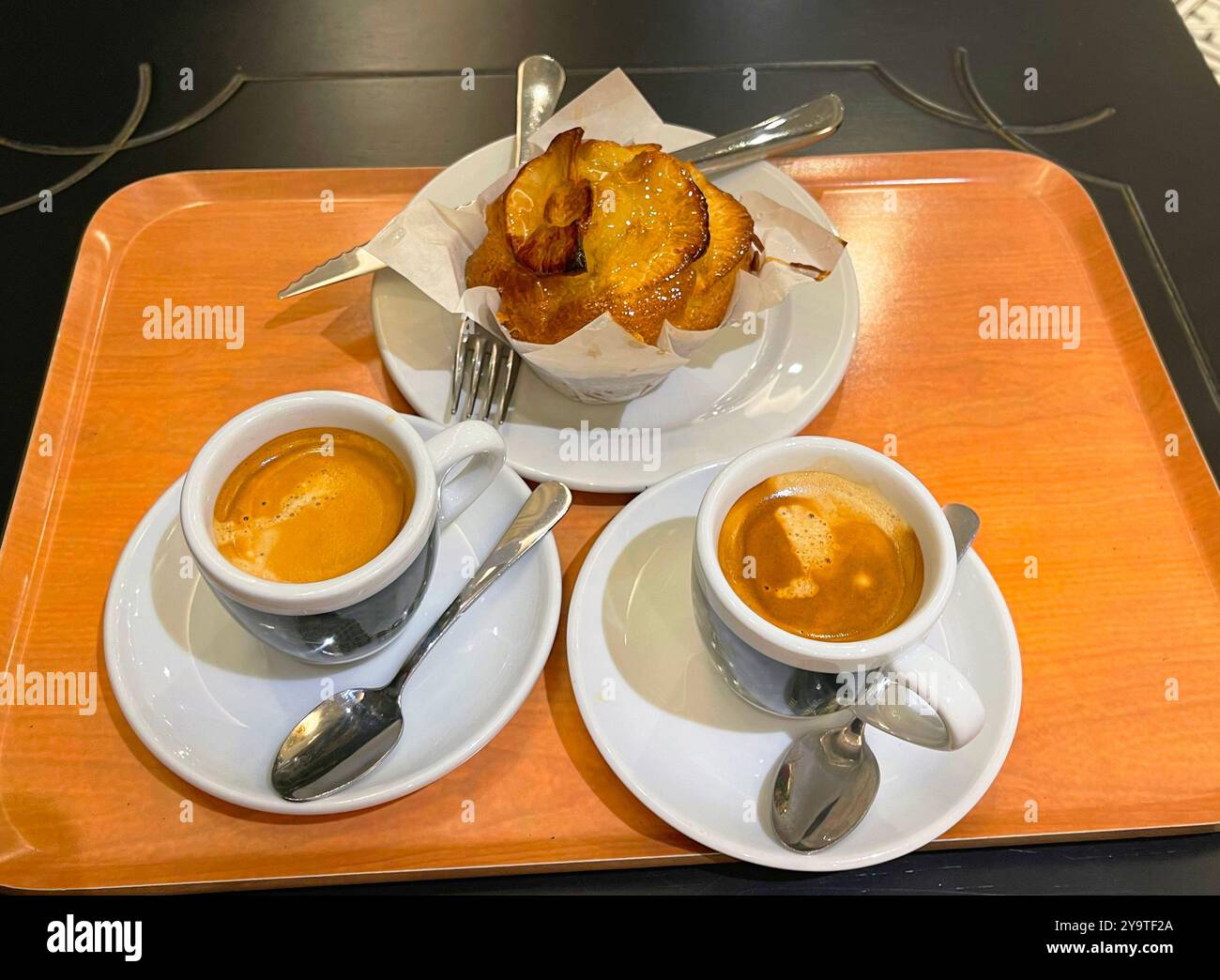Zwei Tassen Kaffee mit Apfelmuffin auf einem Tablett. Stockfoto