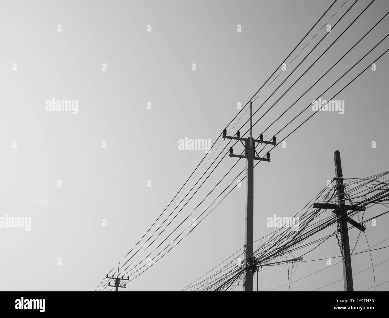 Schwarz-weiß-Foto einer Stahlbetonsäule mit Hochspannungsdrähten vor klarem Himmel. Übertragung von Elektrizität durch Drähte über große Distanz Stockfoto