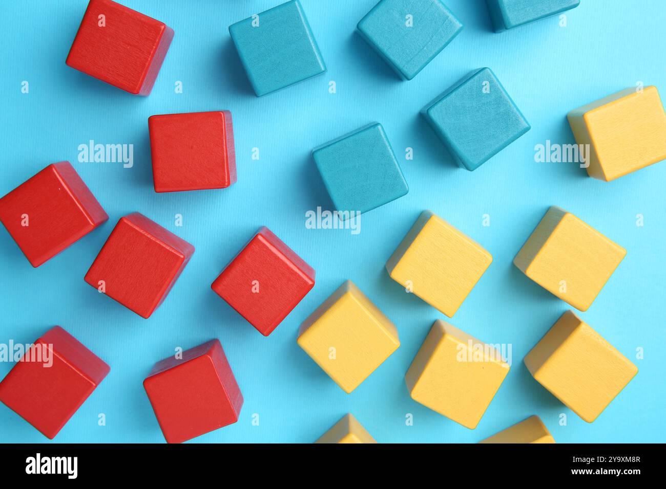 Viele bunte Würfel auf hellblauem Hintergrund, flache Lagen Stockfoto