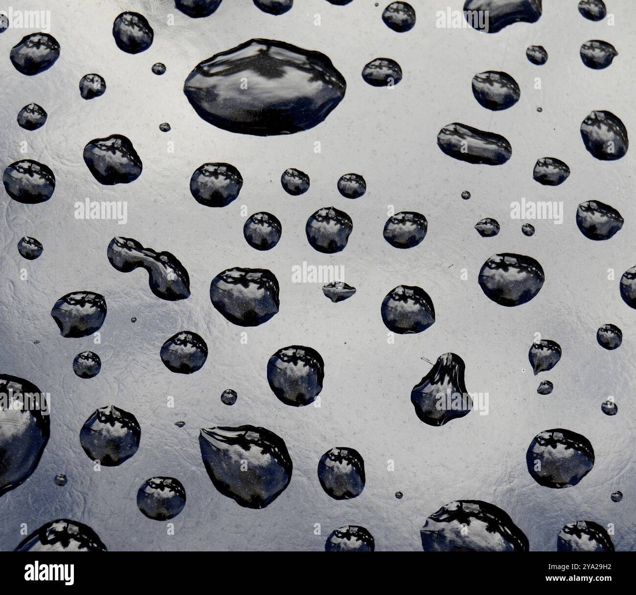 Hintergrund der unberührten Wassertropfen auf schwarze Metall Oberfläche Stockfoto