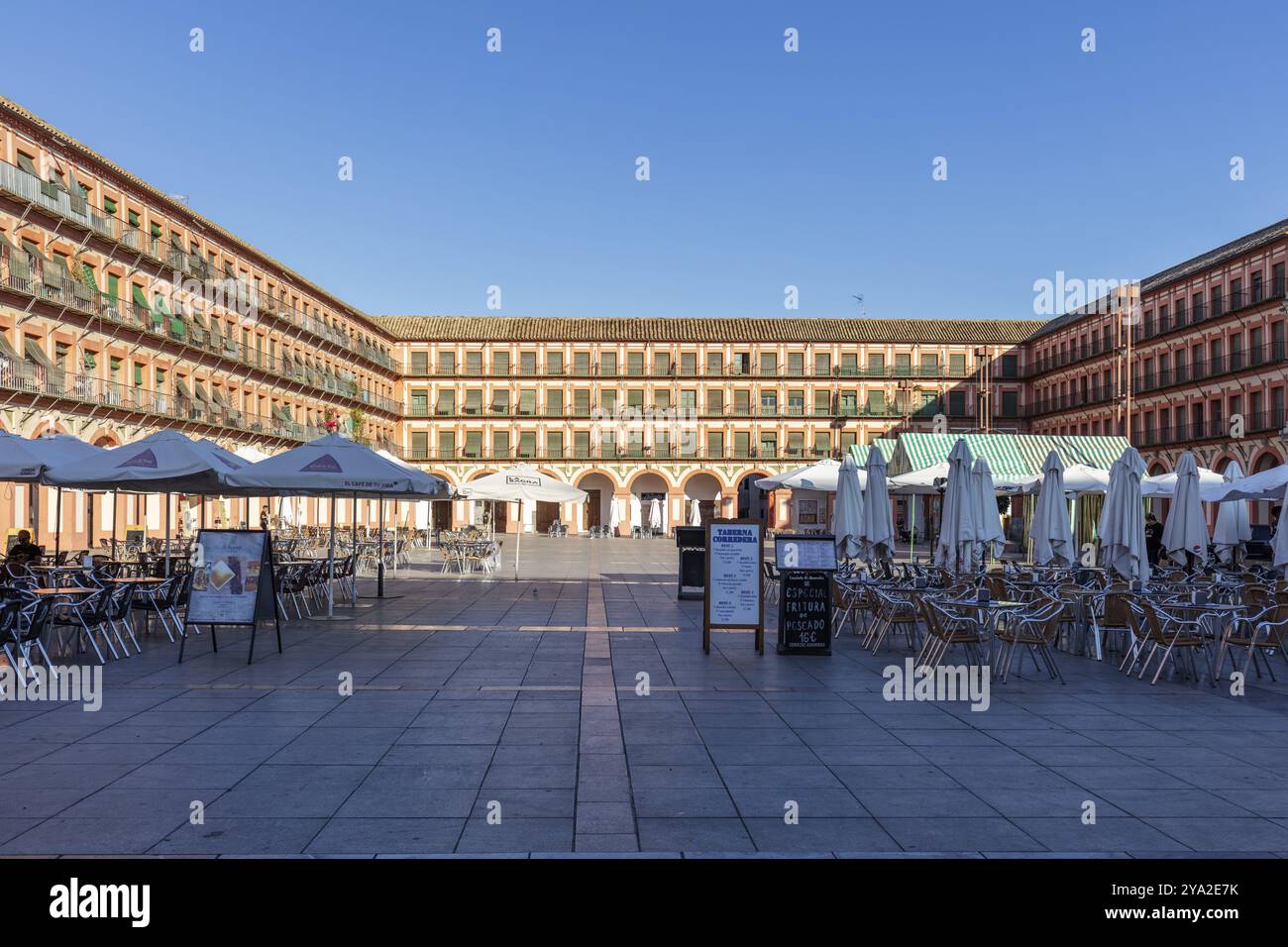 Großer platz mit Arkaden, voll von Cafétischen und Sonnenschirmen, abendliche Atmosphäre mit geselliger Atmosphäre, Cordoba Stockfoto