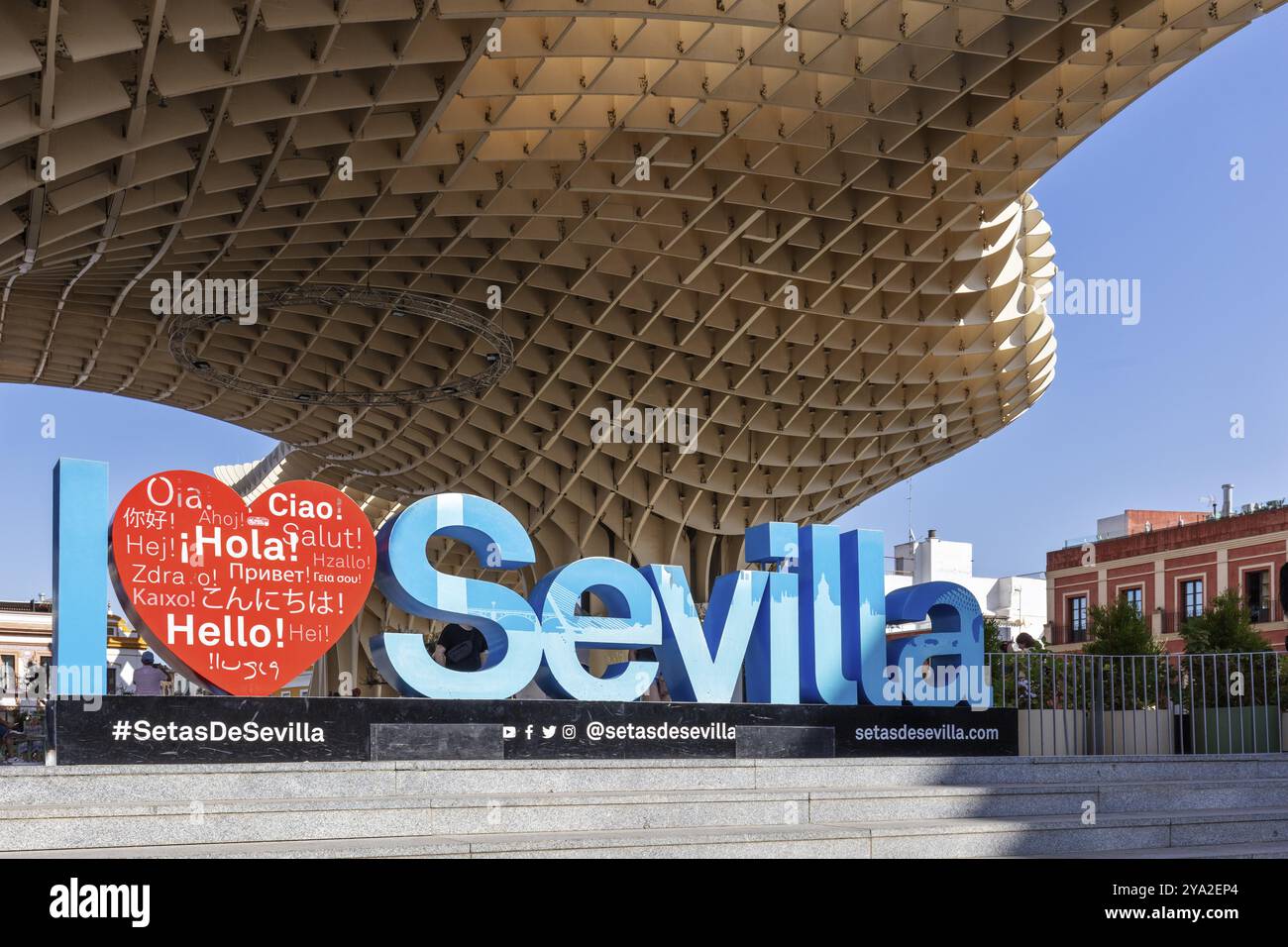 Begrüßungsschild in verschiedenen Sprachen vor der imposanten Architektur des Metropol Parasol, Sevilla Stockfoto