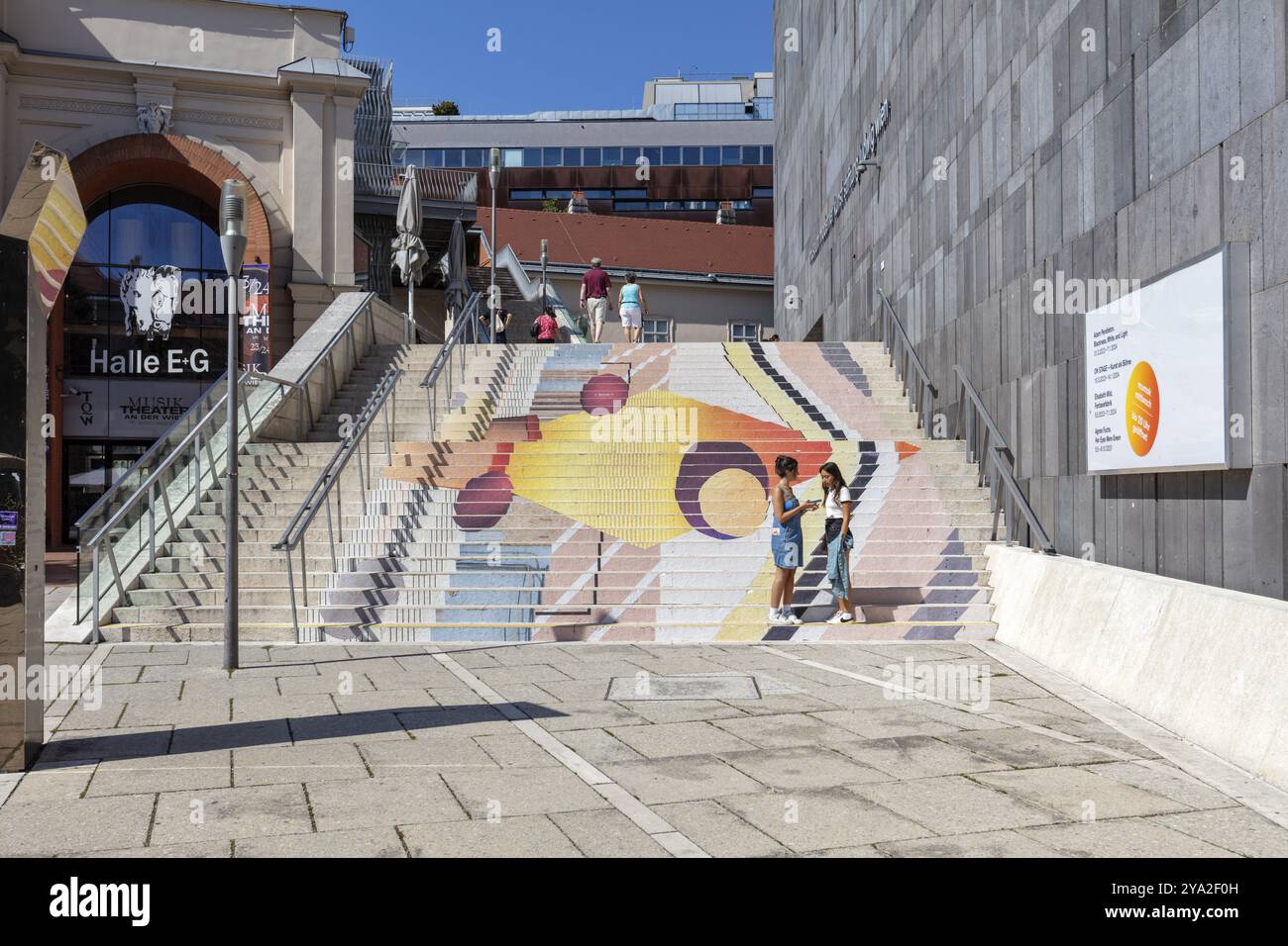 Farbenfrohe Kunstinstallation auf Treppen, animiert von Menschen, in einer urbanen Umgebung, Wien Stockfoto