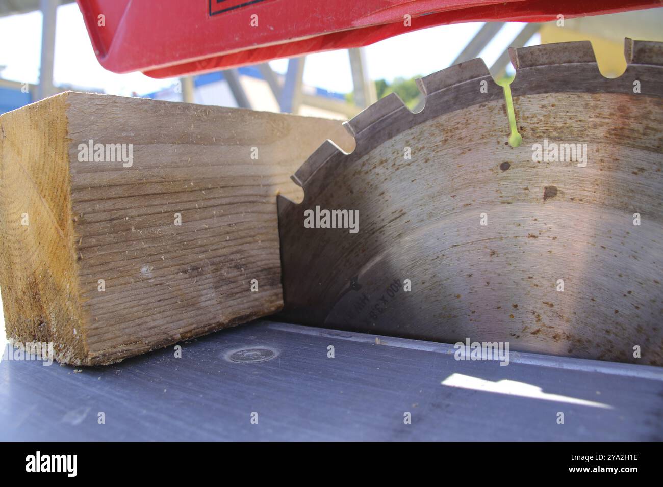 Ein Stück Holz liegt am Sägeblatt einer Kreissäge Stockfoto