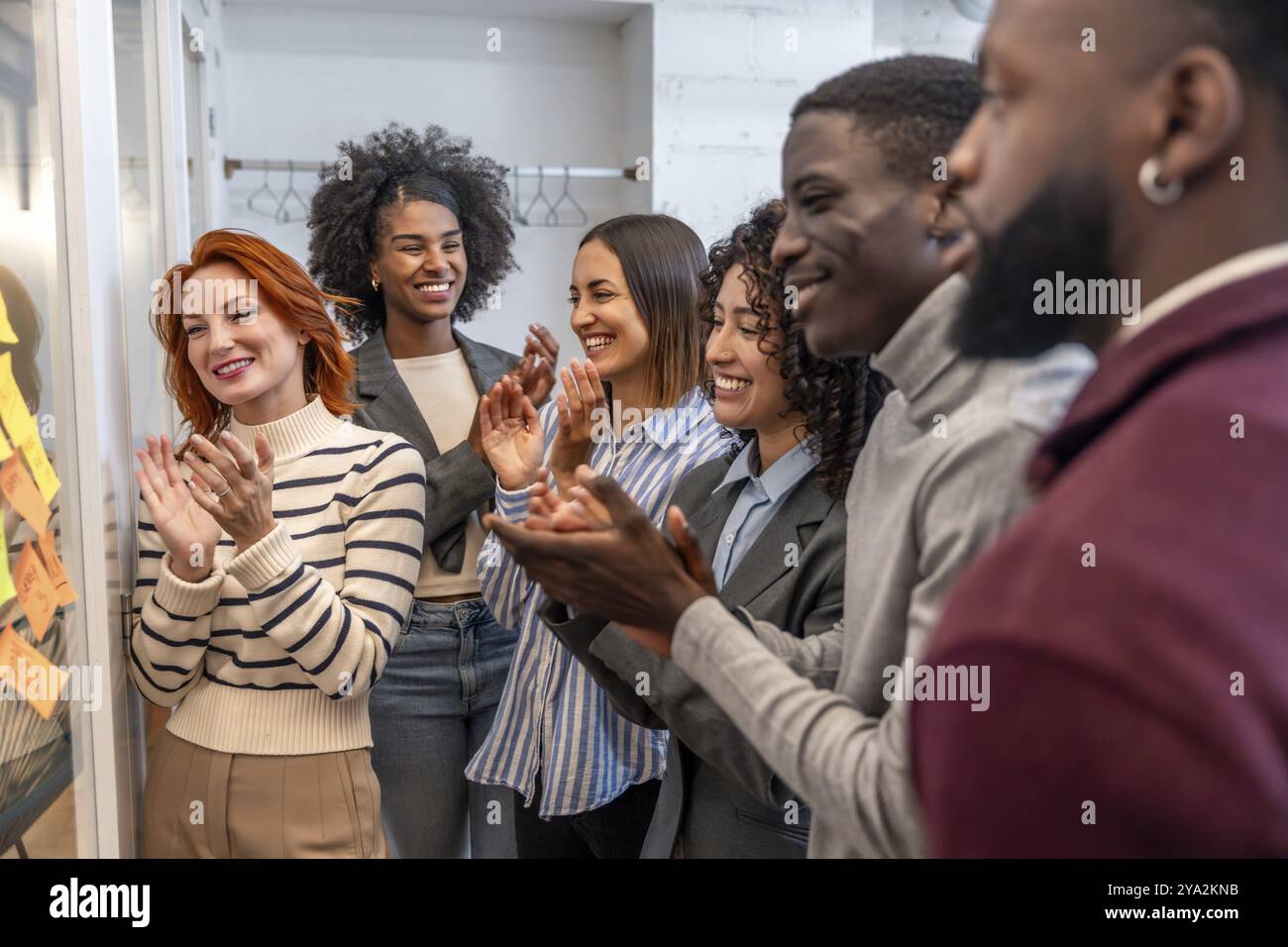 Vielfältige Teamarbeit, die am Ende eines Brainstorming-Meetings in einem Coworking-Raum applaudiert Stockfoto