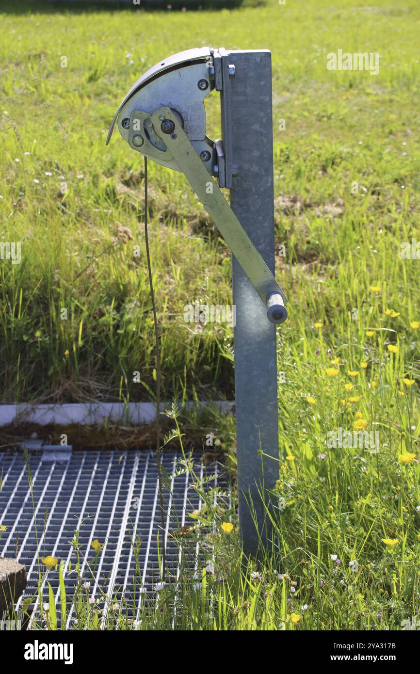 Die Seilwinde aus Edelstahl steht auf einem Gitter auf einem Regenwasserbecken Stockfoto