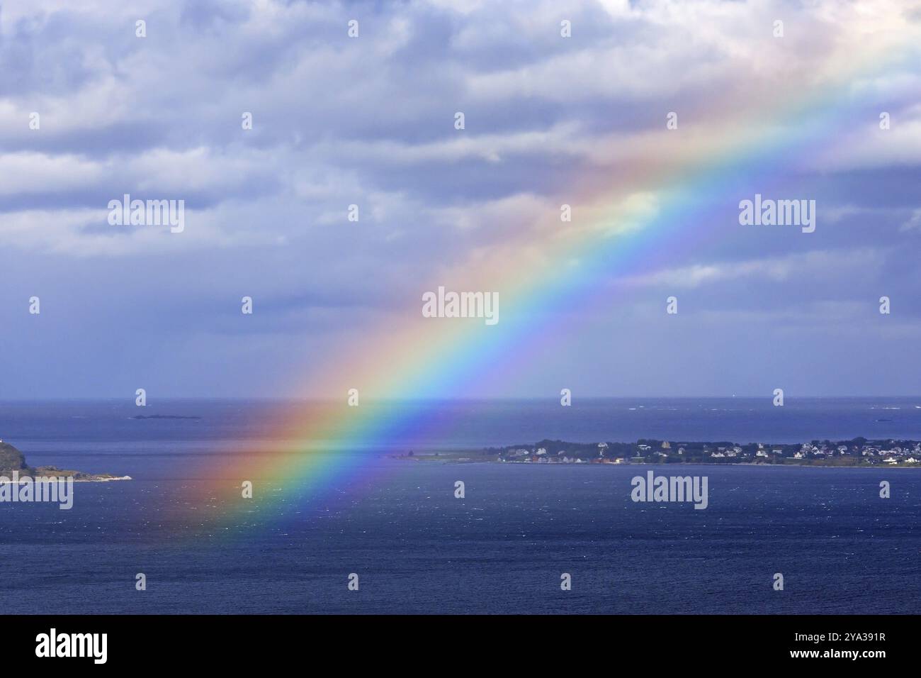 Regenbogen über dem Atlantik vor Alesund in Norwegen, Norwegisches Meer farbenfroher und bewölkter Sonnenaufgang über dem Norwegischen Meer in der Nähe von Alesund in Norwegen Stockfoto