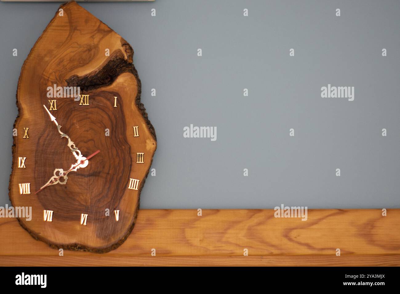 Hölzerne Uhr, handgefertigte Holzwand analoge natürliche Uhr aus Baumstamm mit römischen Ziffern Stockfoto