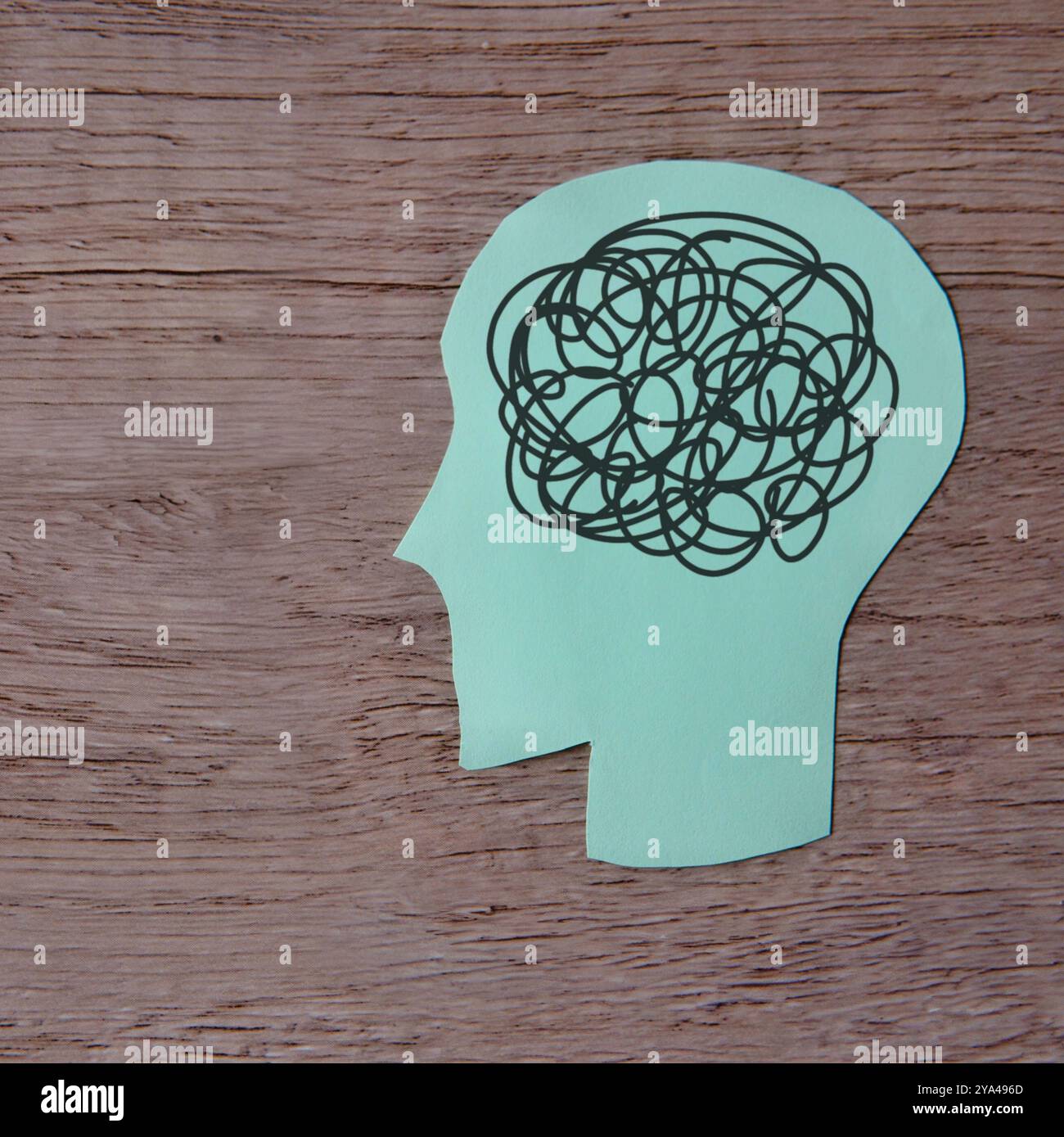 Papierausschnitt eines menschlichen Kopfes mit verworrenen schwarzen Linien. Psychische Gesundheit. Komplexitäten des Denkens, überdenkendes Konzept. Stockfoto