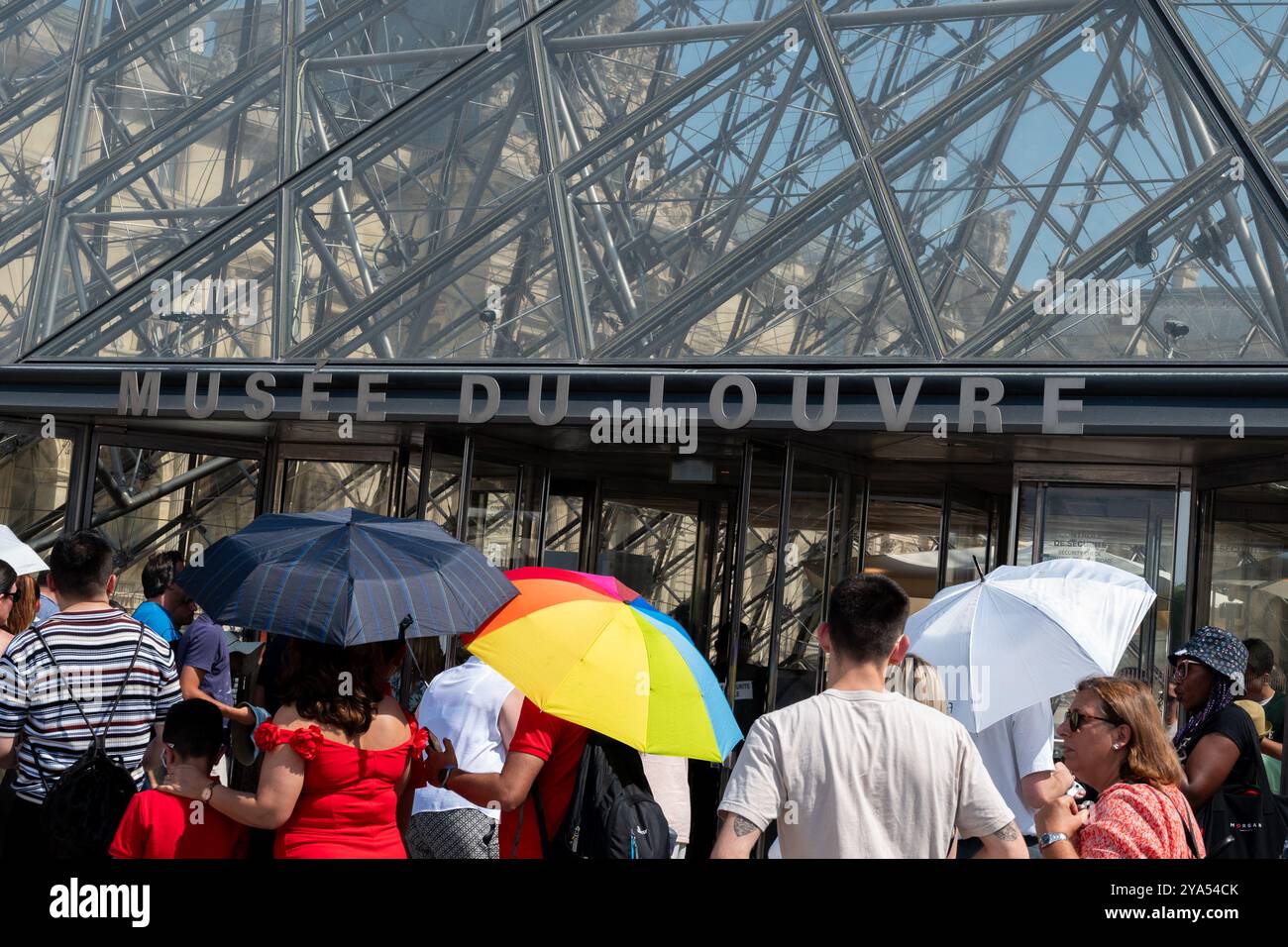 Menschen in sengender Mittagssonne stehen in der Schlange, um den louvre in Paris zu betreten Stockfoto