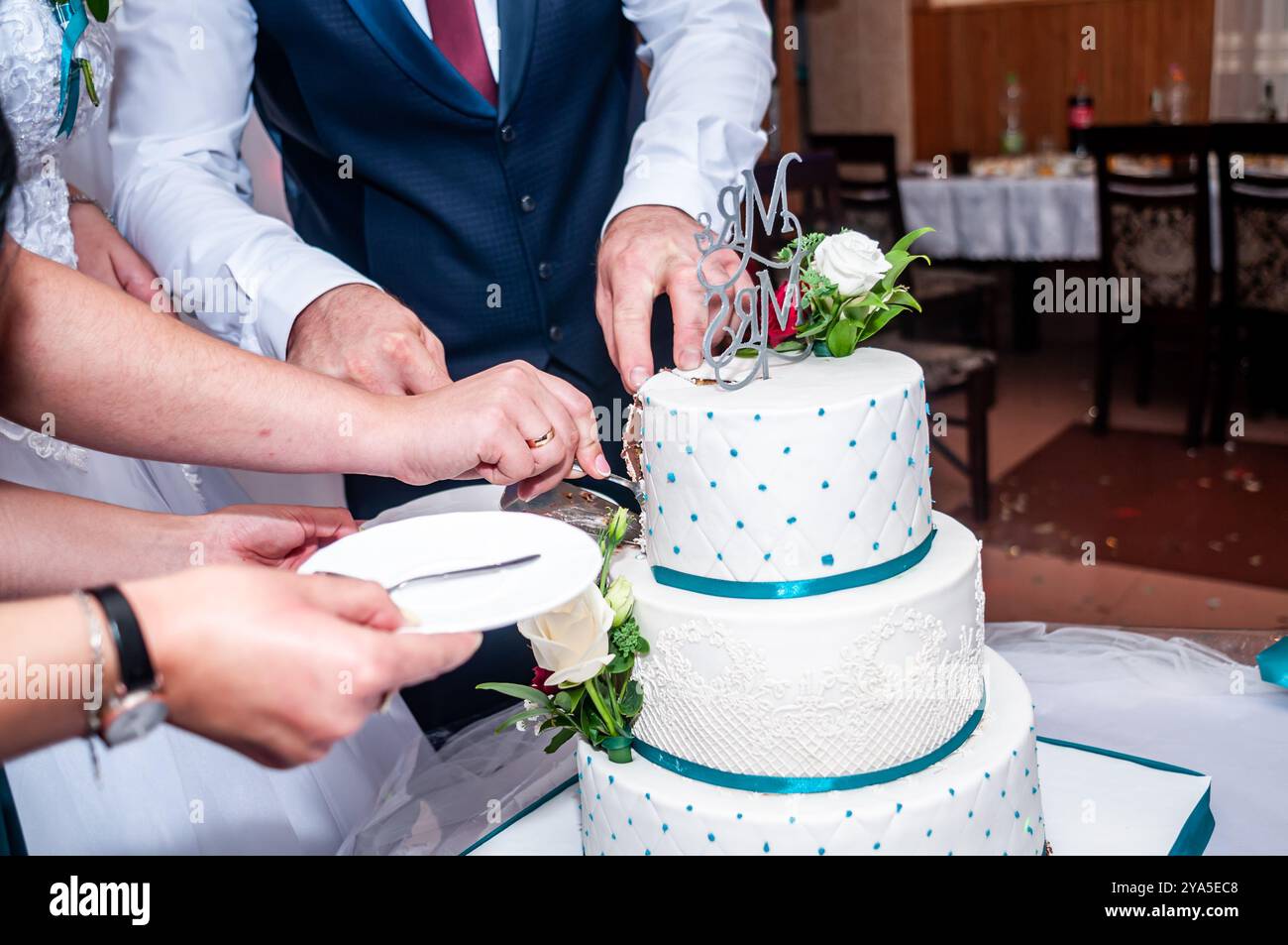 Elegante Zeremonie zum Schneiden von Hochzeitstorten zur Feier von Liebe und Einheit. Stockfoto