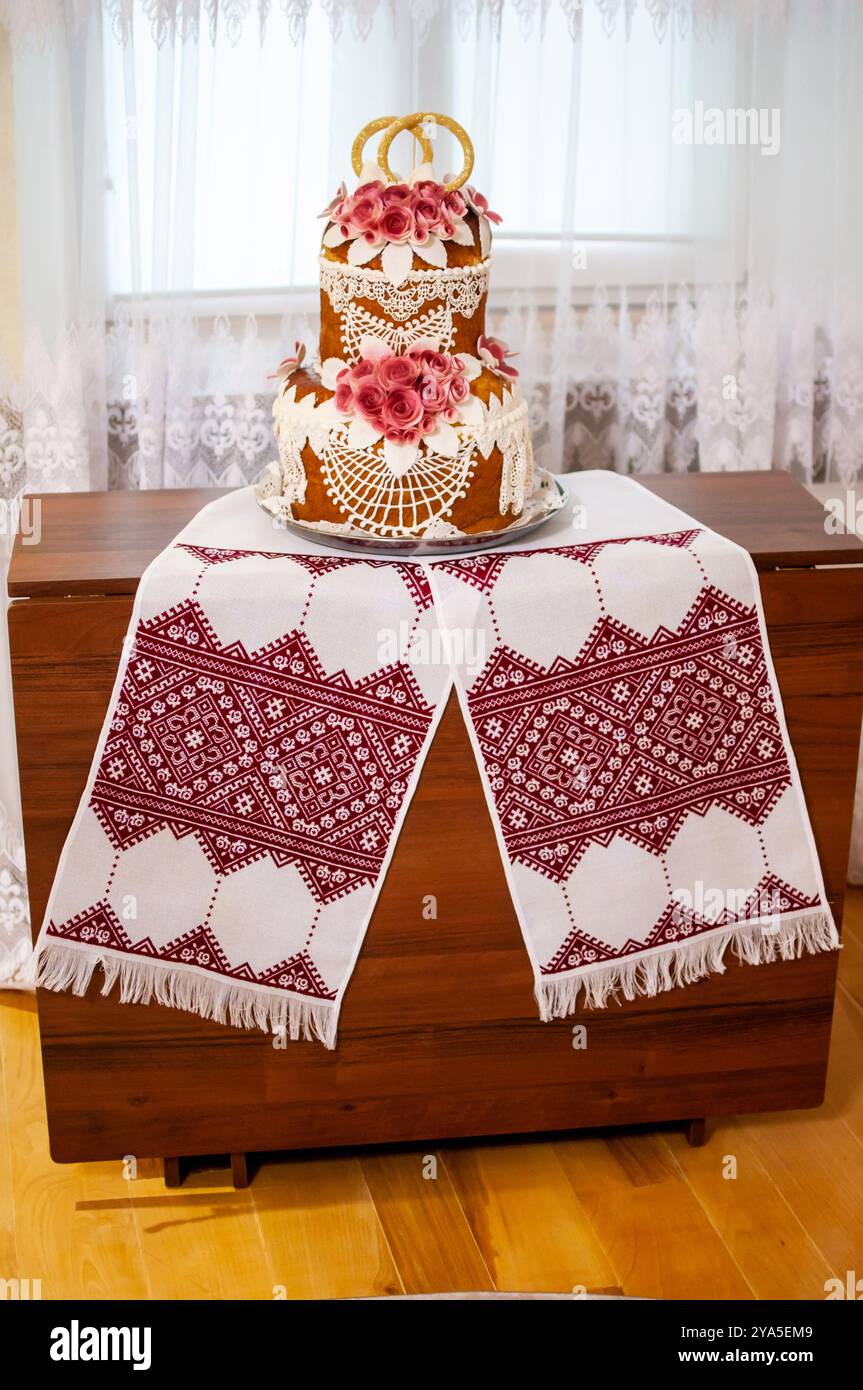 Exquisite Tradition: Ein wunderschön dekorierter Hochzeitstorte mit elegantem Tischdekor. Stockfoto