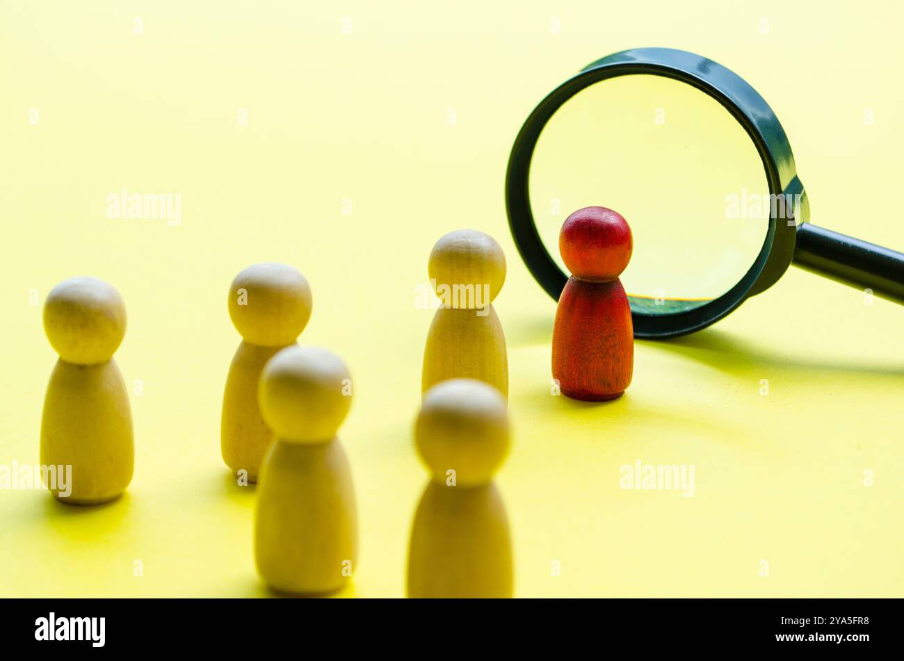 Eine rote Holzfigur, die jemanden repräsentiert, der als Anführer ausgewählt wurde. Führungskonzept. Stockfoto