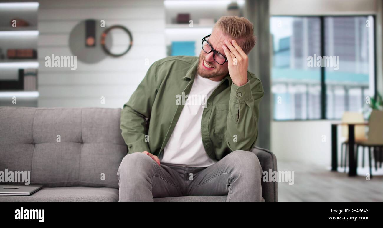 Sorgte Mitte der erwachsene Mann leidet unter Kopfschmerzen zu Hause Stockfoto