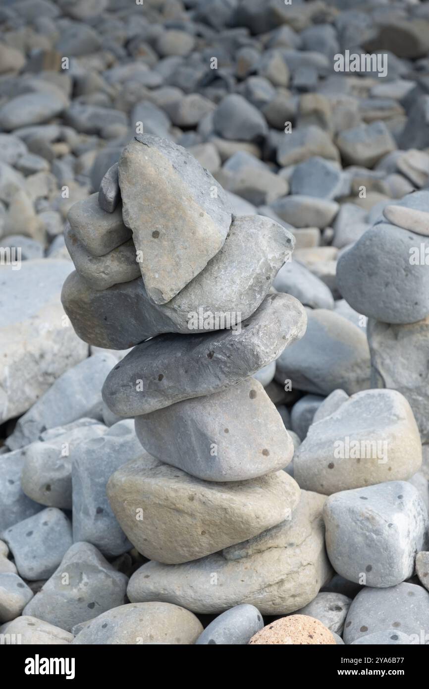 Kieselsteine stapelten sich übereinander an einem felsigen Strand Stockfoto