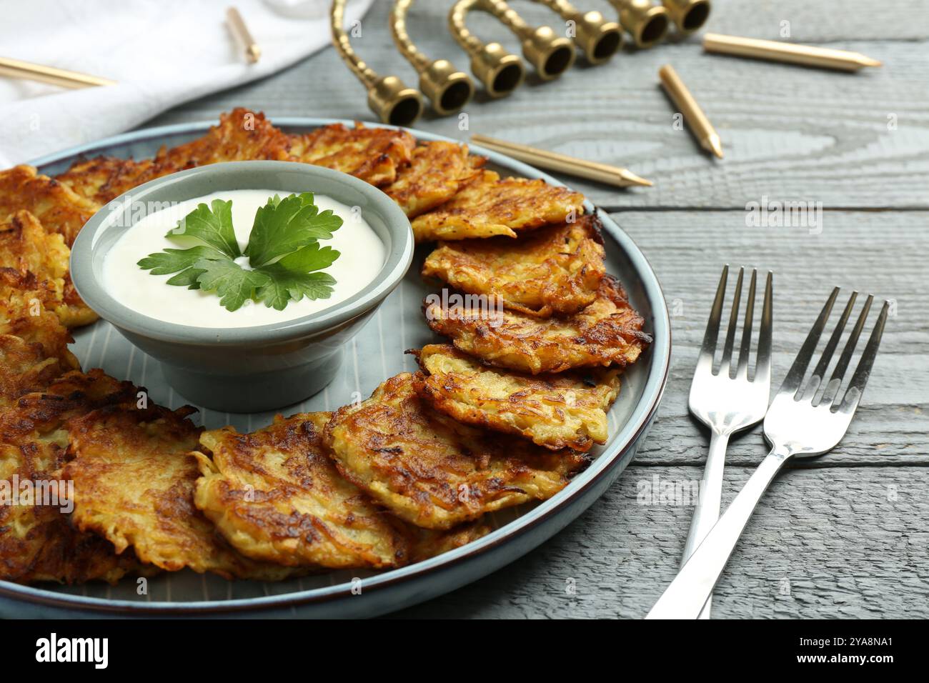 Köstliche Kartoffelpfannkuchen serviert auf grauem Holztisch, Nahaufnahme. Hanukkah festliches Essen Stockfoto