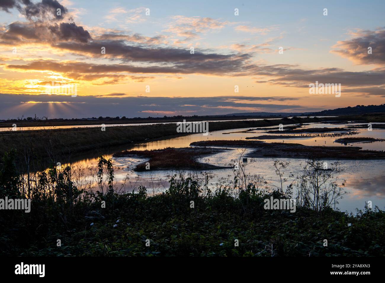 Sonnenuntergang über der Lagune vom Vogelhäuschen der RSPB auf Two Tree Island. Stockfoto