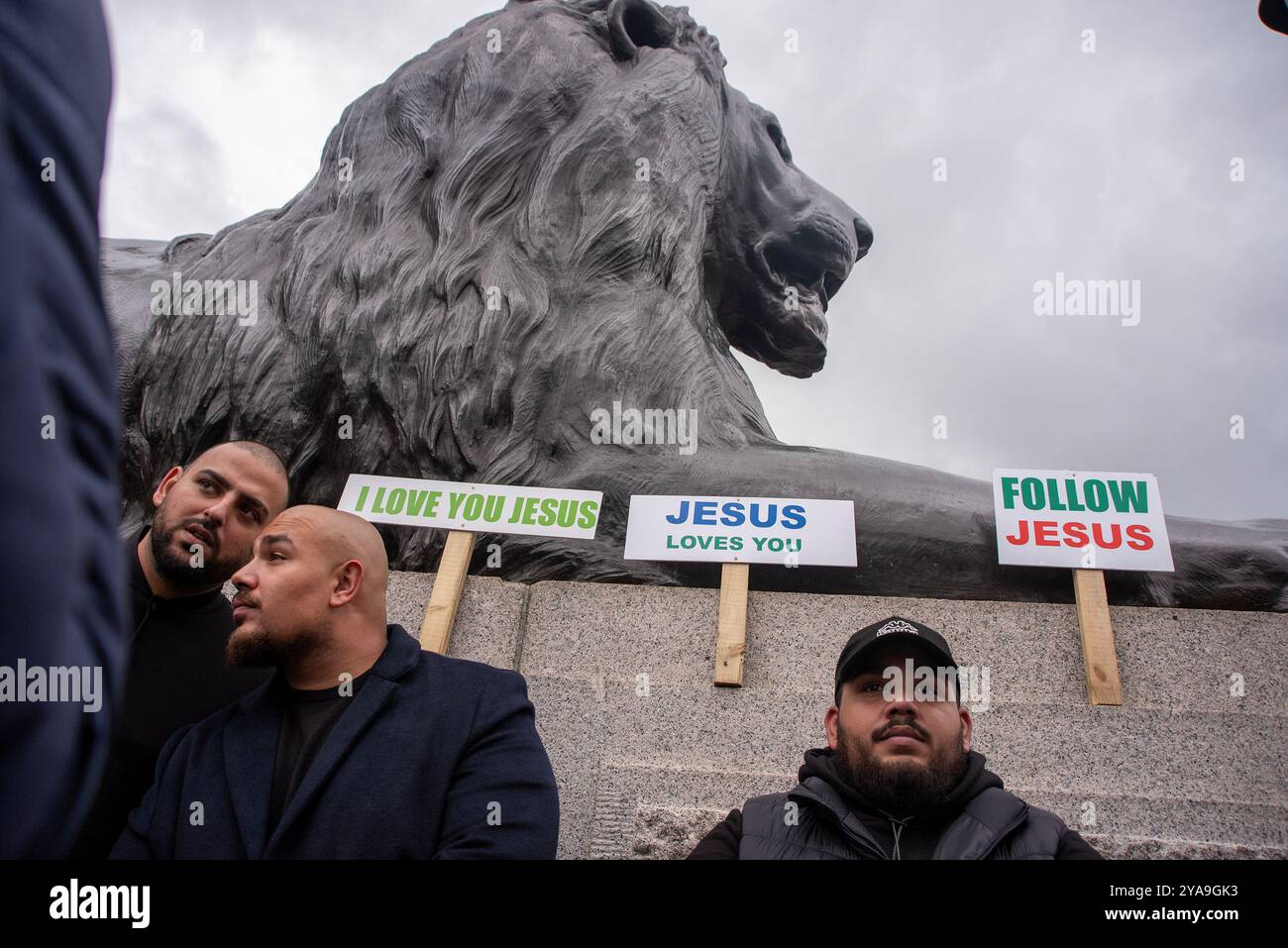 London, Großbritannien. Oktober 2024. Während des marsches legten die Gläubigen ihre Plakate neben einem der Landseer-Löwen auf dem Trafalgar-Platz auf. Hunderte von Christen marschierten durch das Zentrum Londons, während der Veranstaltung „Marsch für Jesus“ genannt wurde. Es ist eine Prozession des Lobes auf den Straßen der Stadt und feiert die Herrschaft Jesu Christi. Quelle: SOPA Images Limited/Alamy Live News Stockfoto