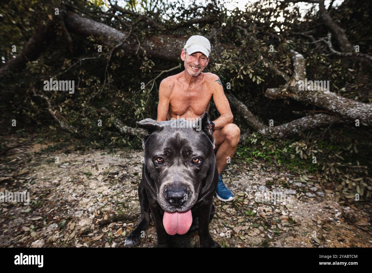 Dade City, Florida, USA. Oktober 2024. Tommy und sein Hund Athena fotografieren ein Porträt vor ihrem zerschlagenen Haus im Sawmill Camping Resort Co-op (Credit Image: © Dave Decker/ZUMA Press Wire) NUR REDAKTIONELLE VERWENDUNG! Nicht für kommerzielle ZWECKE! Stockfoto