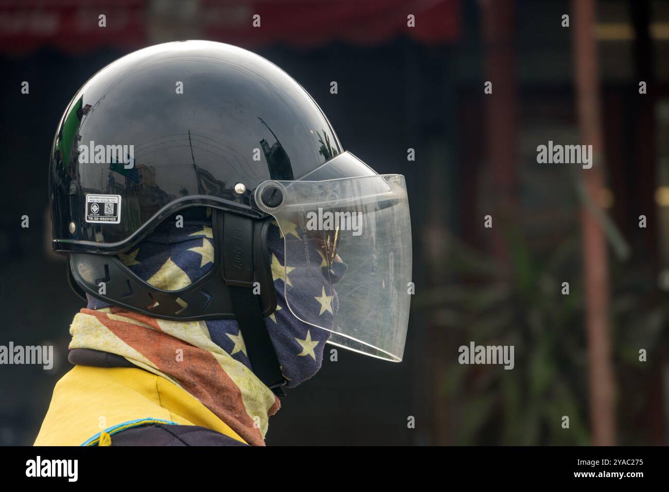 BANGKOK, THAILAND, 09. März 2024, Porträt eines Radfahrers, der einen Helm trägt und sein Gesicht mit dem Schal bedeckt ist Stockfoto