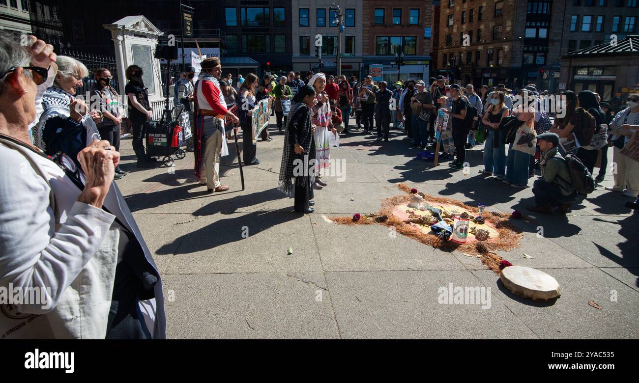 Boston, Massachusetts, USA. 12. Oktober 2024. März zum Tag der indigenen Völker. Etwa 100 Ureinwohner versammelten sich am Boston Common im Zentrum von Boston und marschierten durch das Zentrum der Stadt, um den Tag der Indigenen Völker zu unterstützen, der den Columbus Day am zweiten Montag im Oktober ersetzte. Vor dem marsch führt Rosalla eine indigene Frau diejenigen an, die sich in einer Zeremonie der Ureinwohner versammelt haben, an einem für die Veranstaltung geschaffenen Altar. Quelle: Chuck Nacke / Alamy Live News Stockfoto