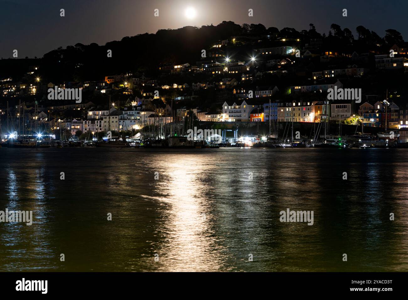 Blick vom Dartmouth Quay auf einen Mondaufgang über Kingswear mit Mondlicht auf dem Fluss Dart, vertäute Boote und beleuchtete Gebäude Nr. 3 Stockfoto Blick vom Dartmouth Quay auf einen Mondaufgang über Kingswear mit Mondlicht auf dem Fluss Dart, vertäute Boote und beleuchtete Gebäude Nr. 3 Stockfoto