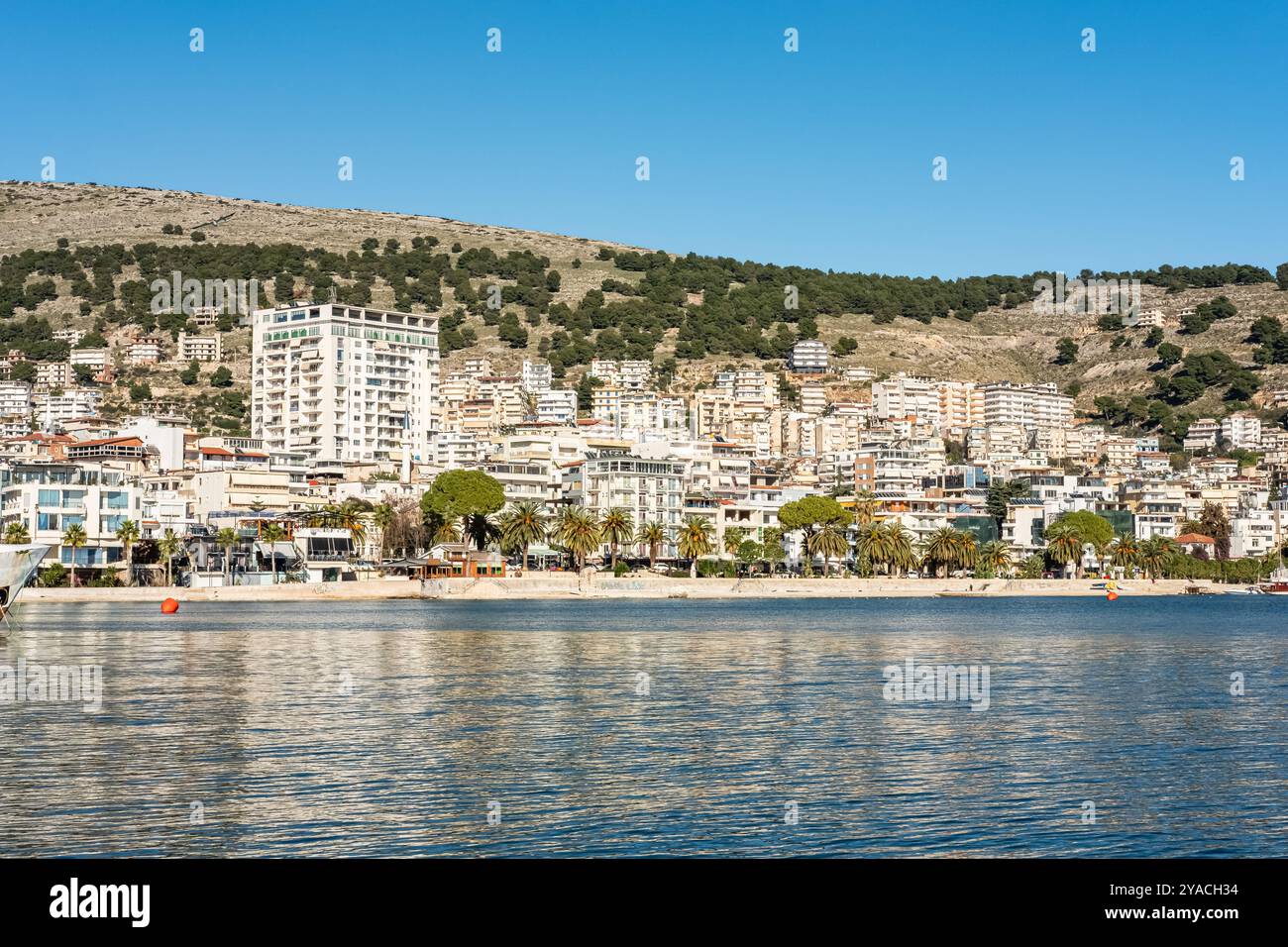 Stadtbild des Hafens von Saranda, Ioninische Meereslandschaft. Helle Morgenszene von Albanien, Europa. Hintergrund des Reisekonzepts. Moderner Stadtdamm auf einem Sunny Stockfoto