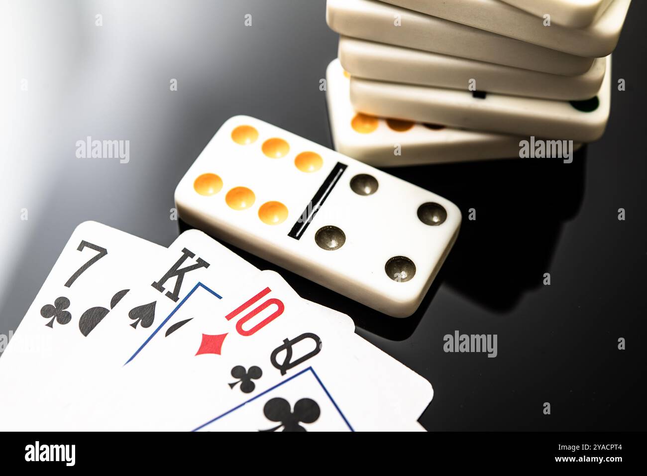 Eine Nahaufnahme von Spielkarten und Dominospielen, die klassische Spiele für Familientreffen, Freizeitaktivitäten und gesellschaftliche Veranstaltungen hervorheben. Perfekt für illustrierte Stockfoto