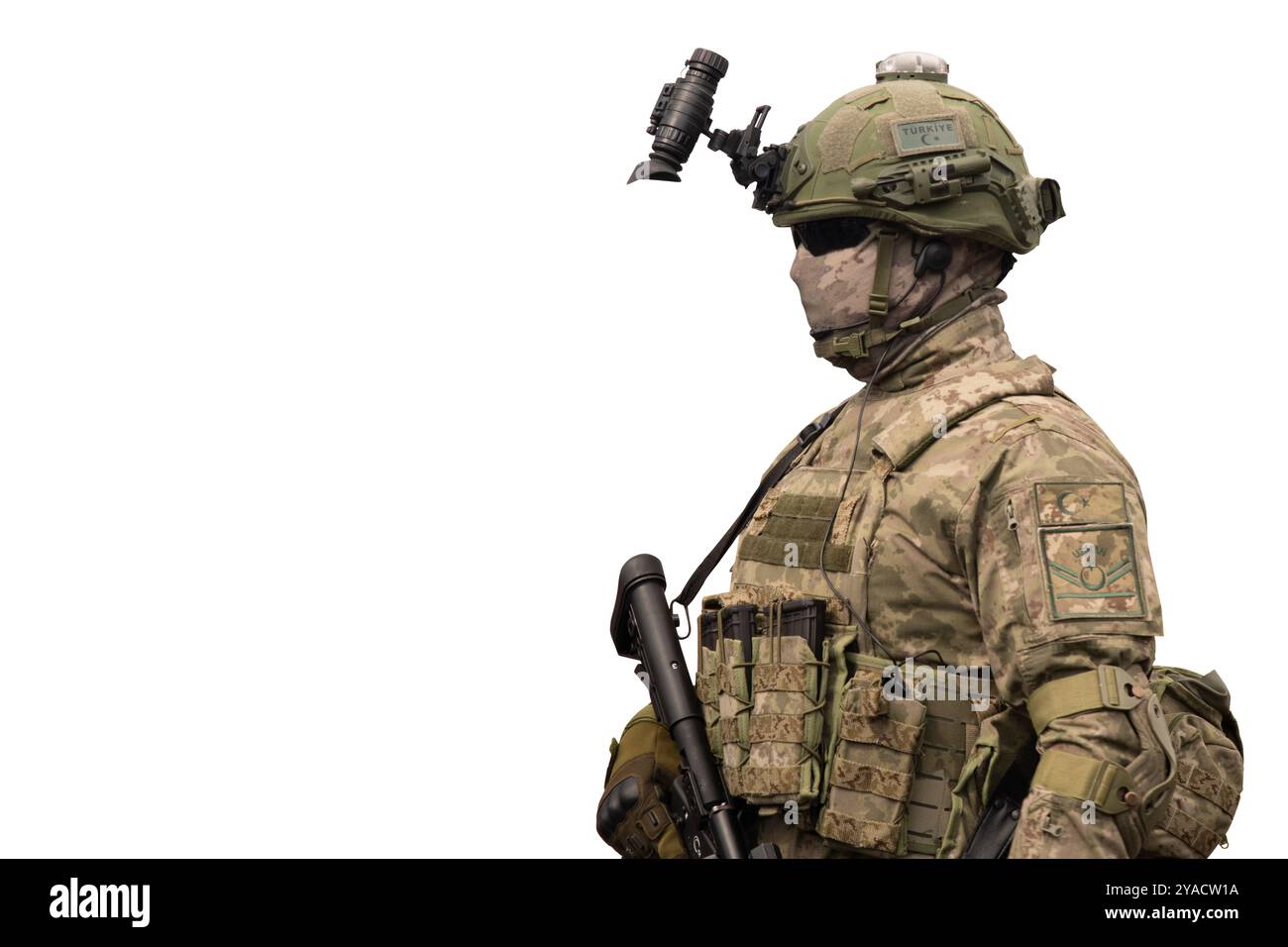 Ein türkischer Spezialeinsatzsoldat in voller taktischer Ausrüstung mit Nachtsichtbrille und Tarnuniform steht vor weißem Hintergrund, bereit für die Arbeit Stockfoto