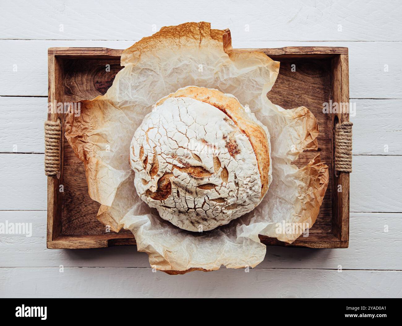 Brot mit selbstgemachtem Sauerteigbrot in der Küche auf Holztablett. Leckerer Vintage-Look. Stockfoto