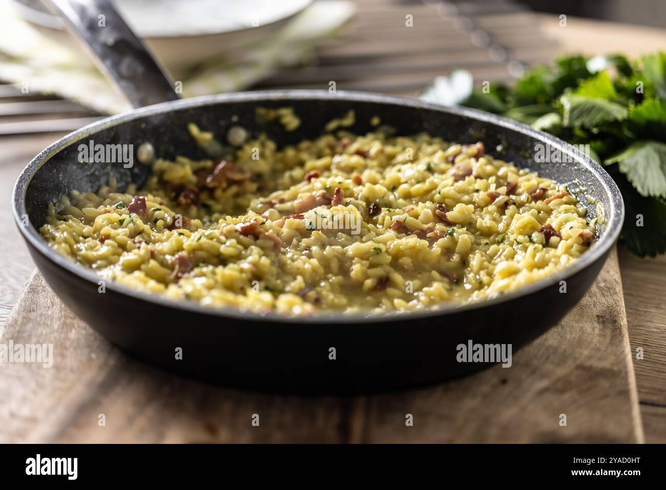 Italienisches Risotto mit Pancetta, Parmesan und Petersilie in einer Pfanne. Stockfoto