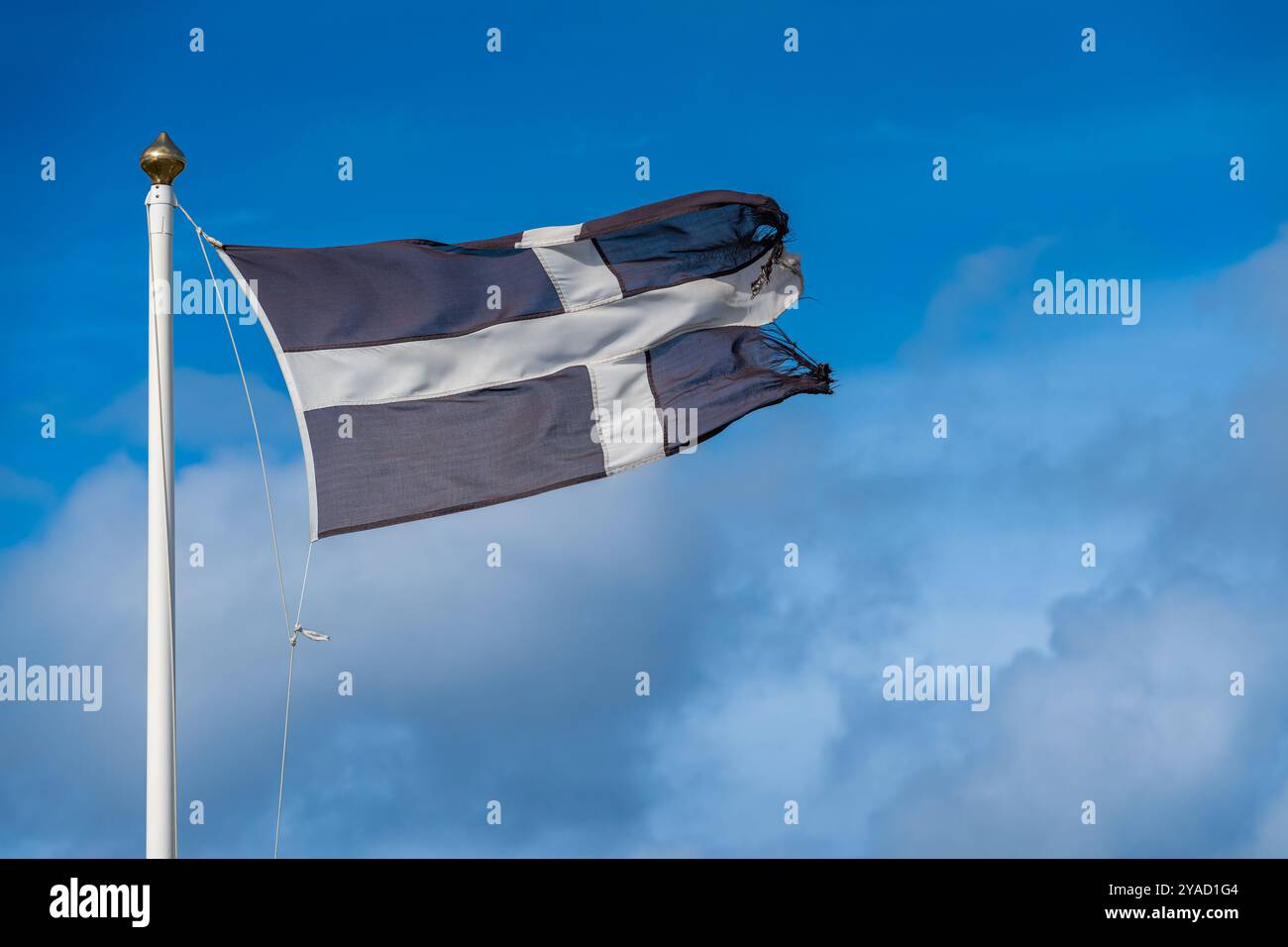 Die kornische Flagge im Wind, die Flagge von St. Piran, weißes Kreuz auf schwarzem Hintergrund Stockfoto