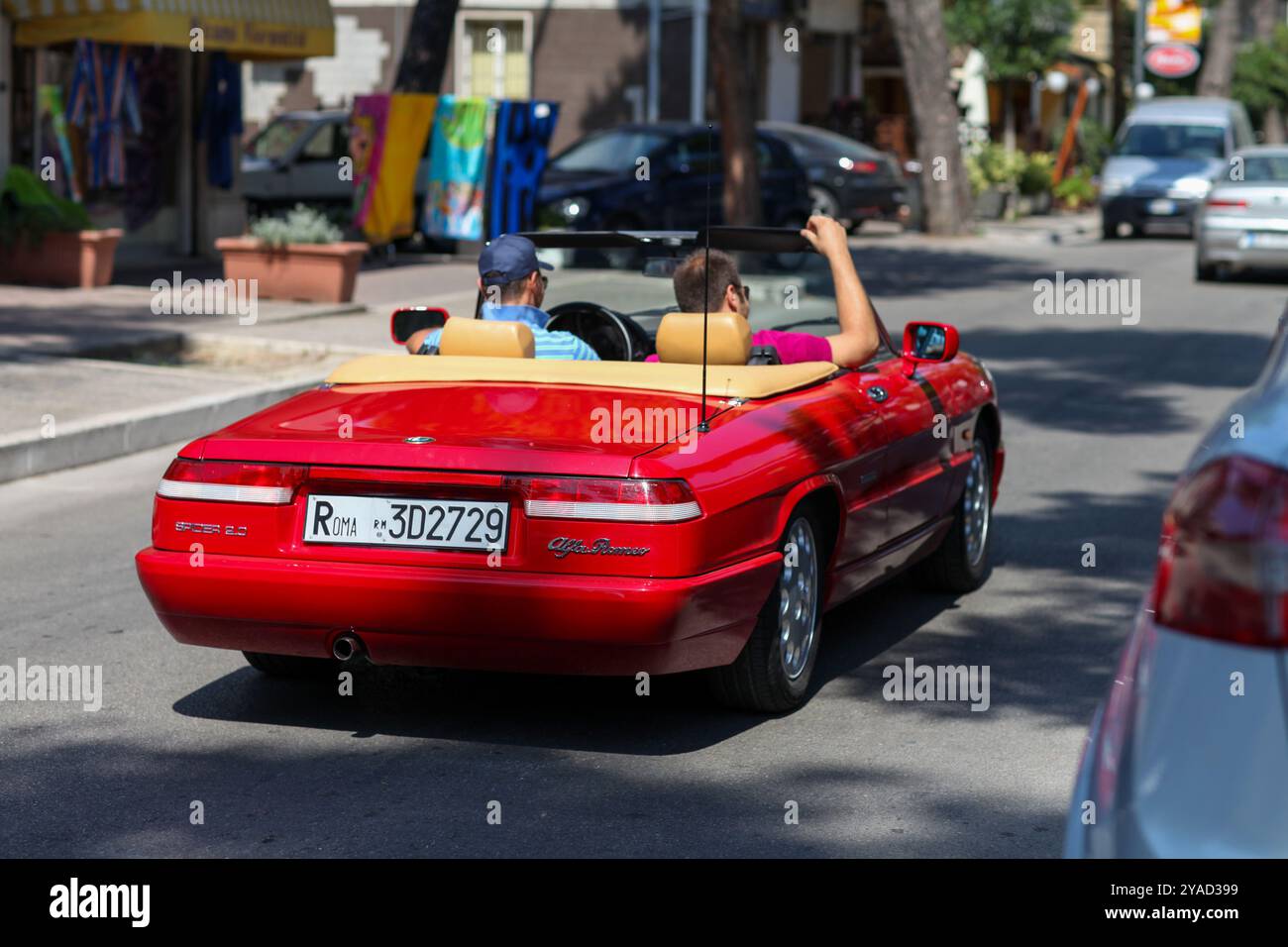 Zwei Freunde fahren an einem sonnigen Sommertag auf der Alfa-Romeo-Spinne. Stockfoto