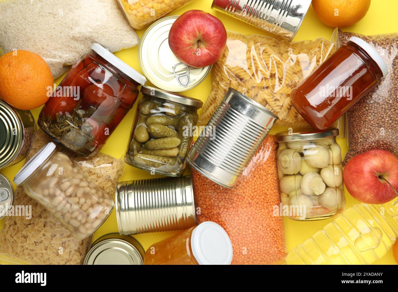 Lebensmittelspende. Verschiedene Produkte auf gelbem Hintergrund, Draufsicht Stockfoto