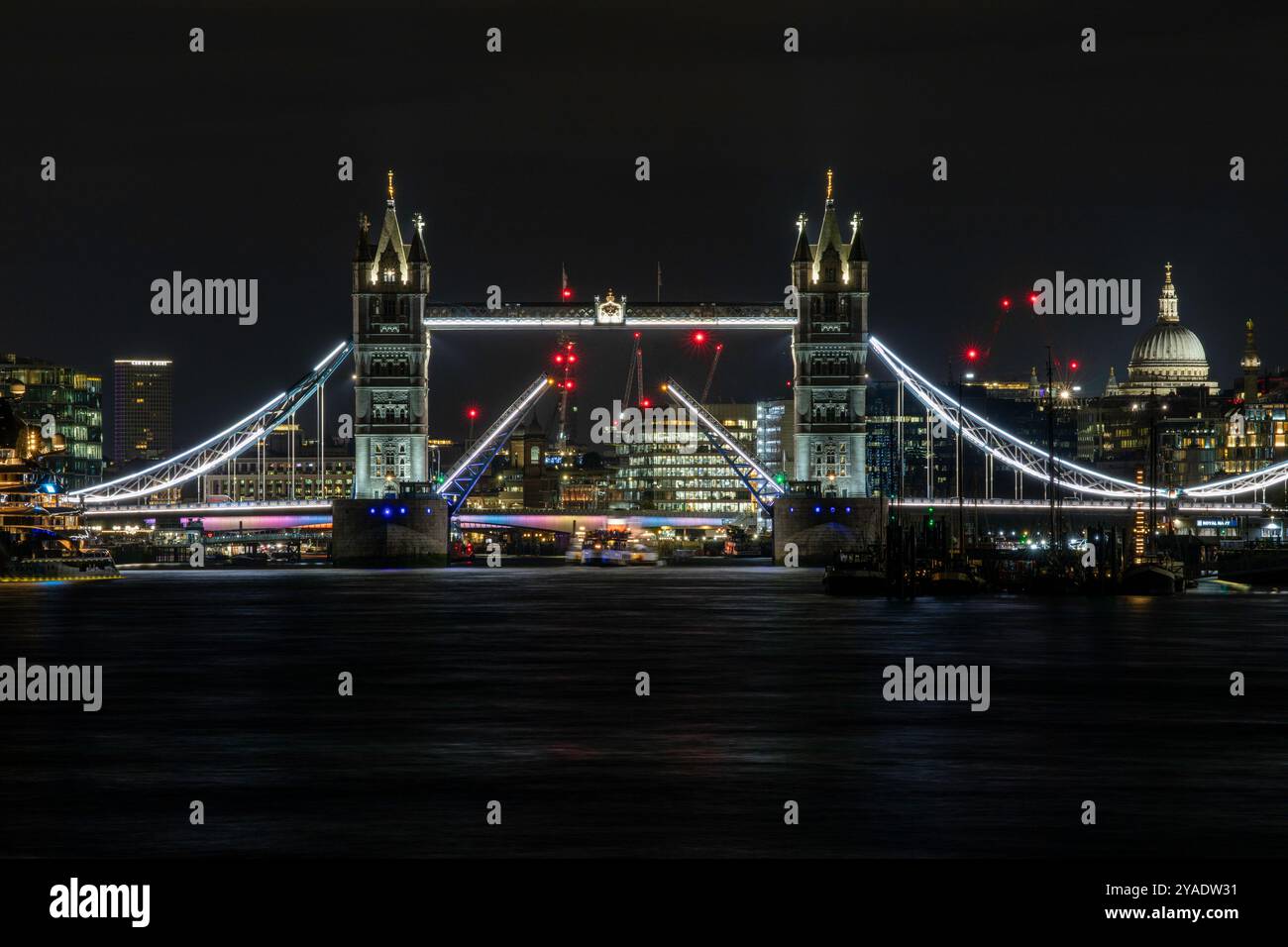 Die Tower Bridge in London wurde geöffnet, um den Waverley-Raddampfer (in der Ferne) durchzulassen. Das Hauptmerkmal ist die offene Brücke, die beleuchtet ist. Stockfoto