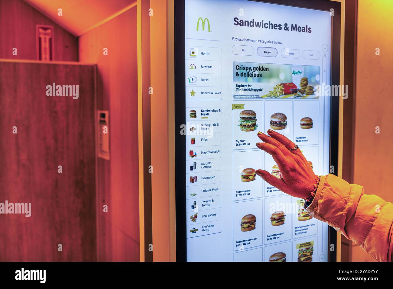 Person, die am McDonald's Kiosk mit digitalem Touchscreen Speisen bestellt und Sandwiches und Mahlzeiten auswählt. New York. USA. Stockfoto
