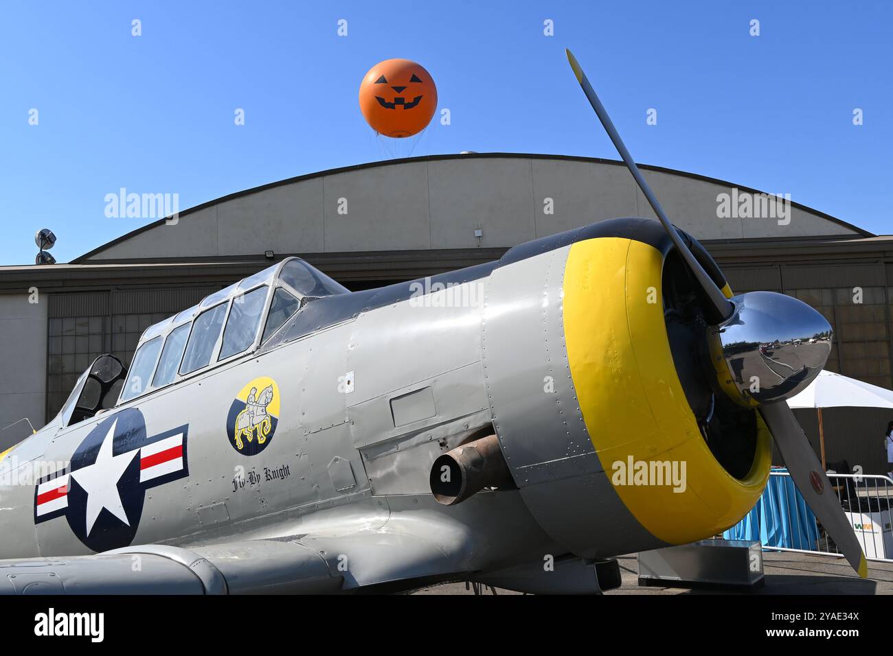IRVINE, KALIFORNIEN - 5. OKT 2024: Antikes Flugzeug im Great Park mit Ballonfahrt mit Kürbisgesicht, das über dem Hangar ragt. Stockfoto