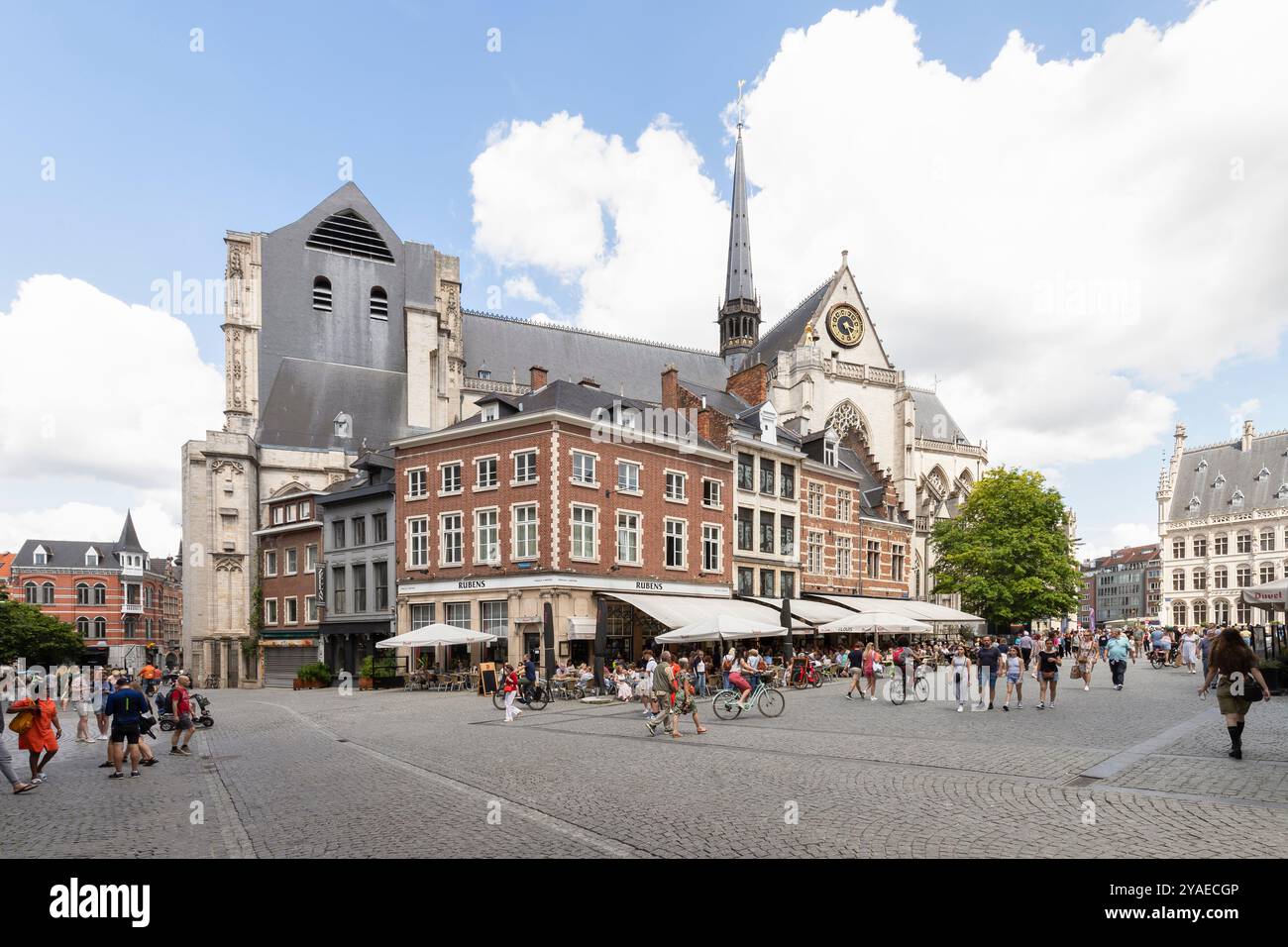 Die Menschen laufen über den Stadtplatz im Zentrum von Leuven mit der Peterskirche im Hintergrund in Belgien. Stockfoto