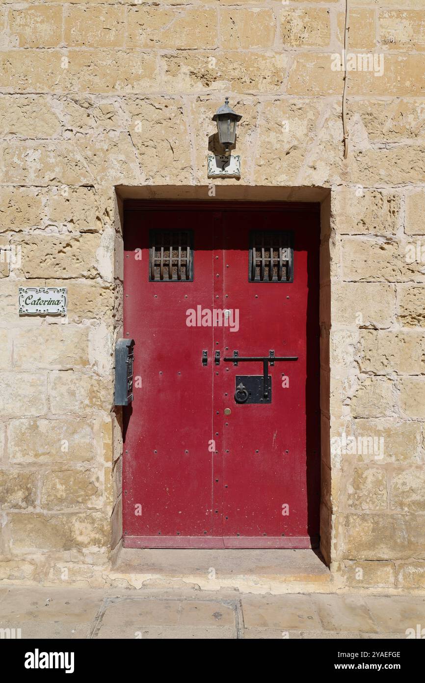 rote Eisentür. Mdina. Malta. Rote Eisentür. 7. Anschlussstücke. Kalkstein. Alt. alt. historisch. Gitter. Raster. Eisengitter. Stockfoto