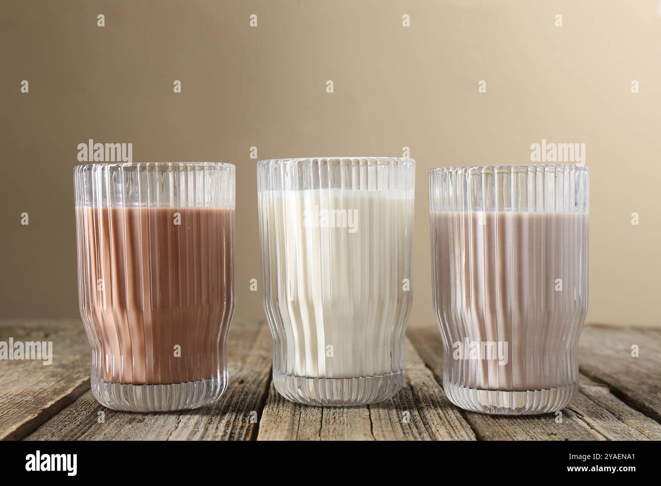 Verschiedene leckere Proteincocktails in Gläsern auf Holztisch Stockfoto