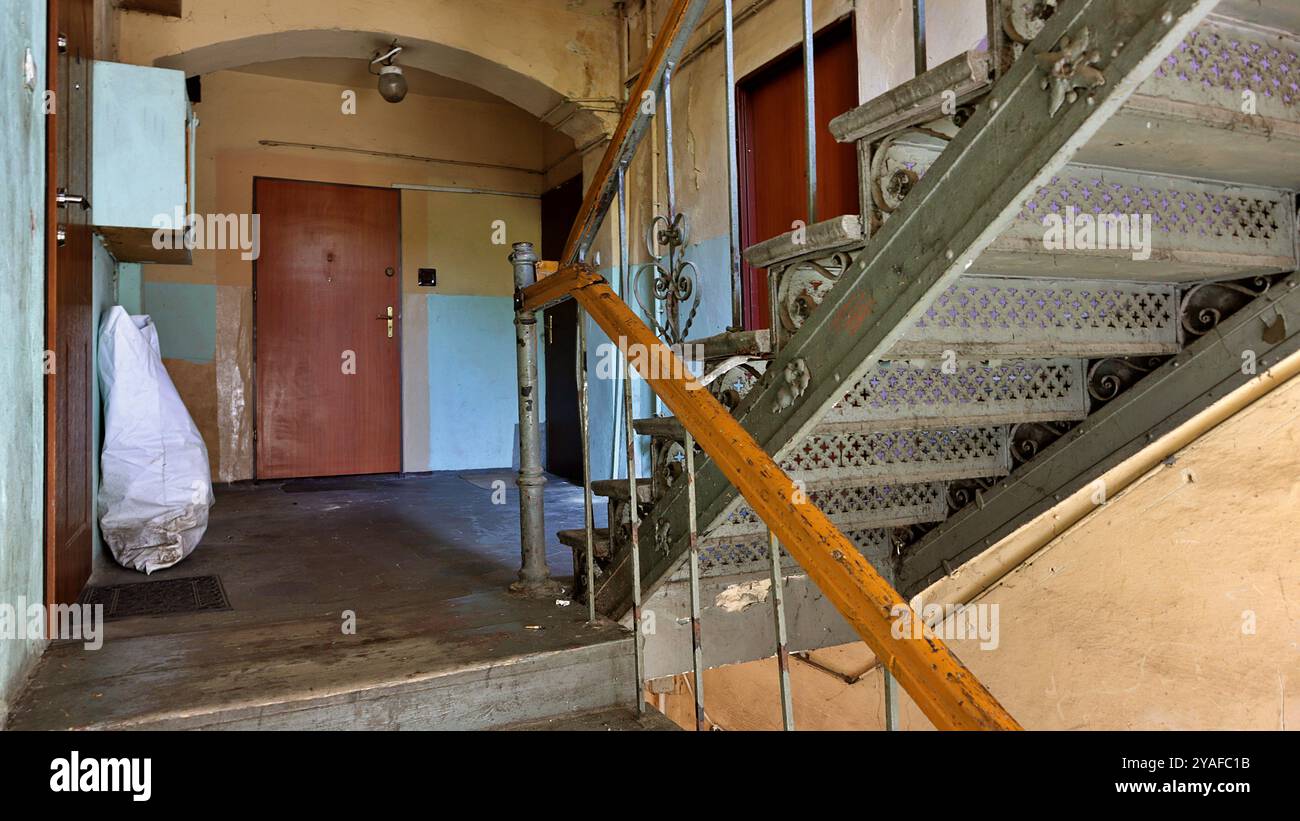 Treppenhaus im Inneren eines 100 Jahre alten Gebäudes mit Holz-, Metall- und Treppengeländern Schlesien, Polen. Stockfoto