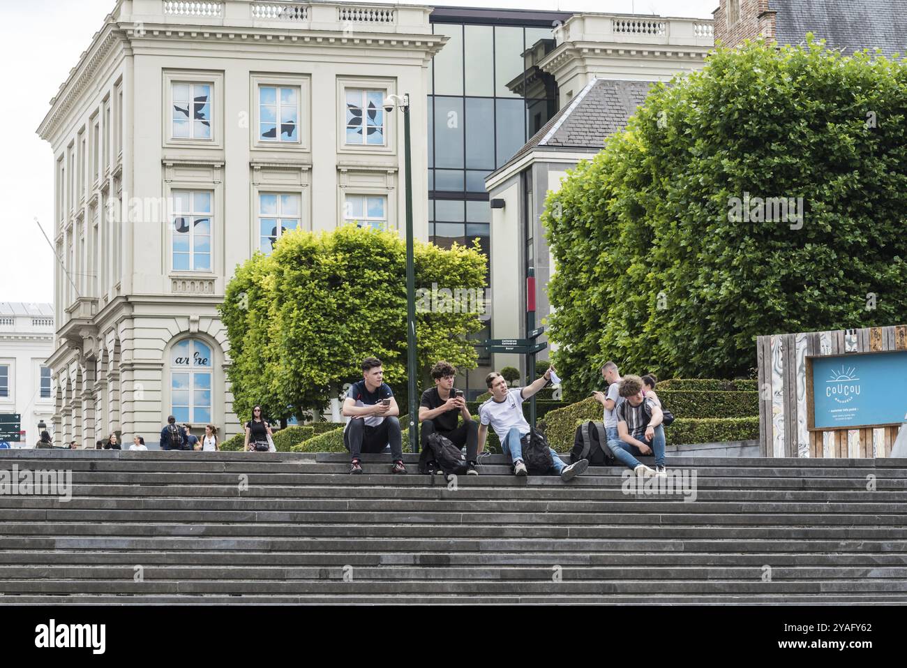 Stadtzentrum von Brüssel, Region Brüssel-Hauptstadt, Belgien, 06 20 2020 Gruppe junger Mann sitzt zusammen an der Treppe des Mont des Arts, Europa Stockfoto