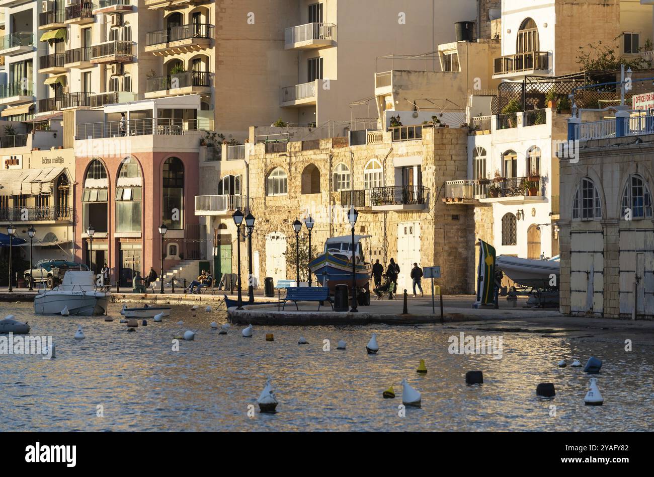 Saint Julian, Malta, 01 07 2022: Kleine Holzschiffe und bunte Häuser an der Bucht, Europa Stockfoto