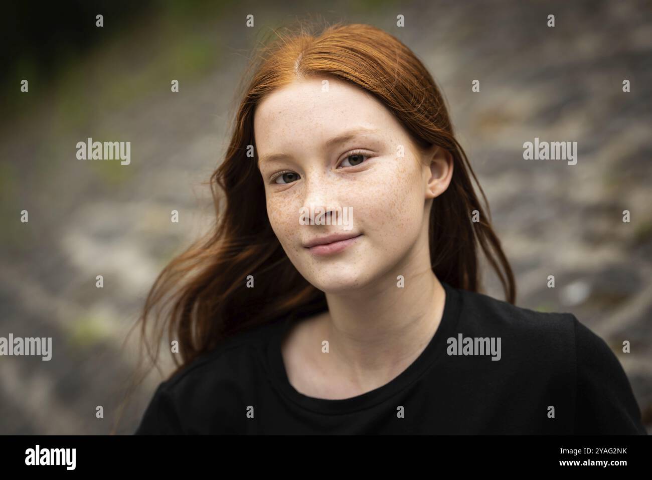 Rothaariges zwölfjähriges Mädchen mit Sommersprossen posiert mit Stadtbokeh-Hintergrund, Jette, Belgien, Europa Stockfoto