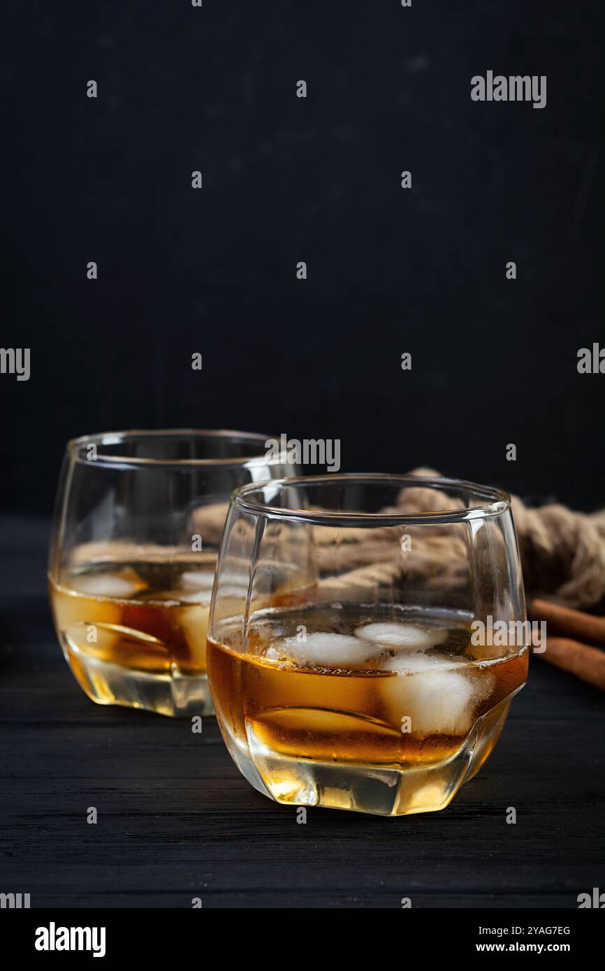 Glas Whiskey mit Eis auf dunklem Hintergrund Stockfoto